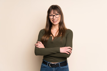 Young woman on ocher background keeping the arms crossed in frontal position