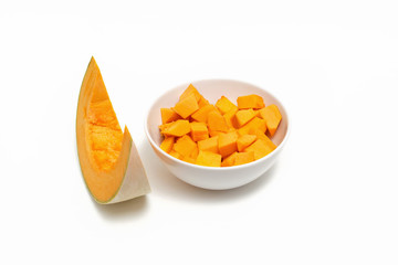 Pumpkin sliced in a white plate on a white background.