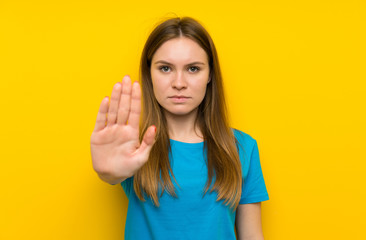 Fototapeta premium Young woman with blue shirt making stop gesture with her hand