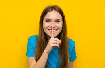 Fototapeta premium Young woman with blue shirt doing silence gesture