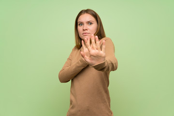 Young woman with turtleneck sweater nervous stretching hands to the front