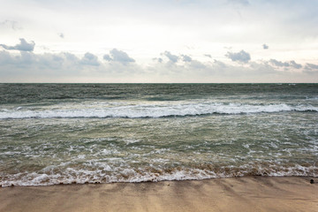 Blue and green waves with white foam on sandy beach. Black Sea, Evpatoria, Crimea, Russia. Travel, wacation concept. Text copy space.