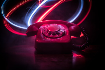 old black telephone on old wood plank with art dark background with fog and toned light. empty space