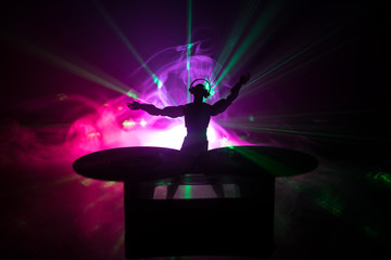 Dj club concept. DJ mixing, and Scratching in a Night Club. Man silhouette on vinyl turntable,...