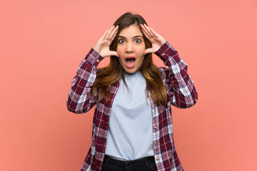 Young girl over pink wall with surprise expression