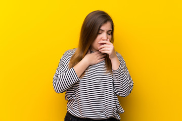 Young girl over yellow wall is suffering with cough and feeling bad