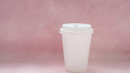 Coffee packing mockup - white paper cup with white cap on light pink background with copy space