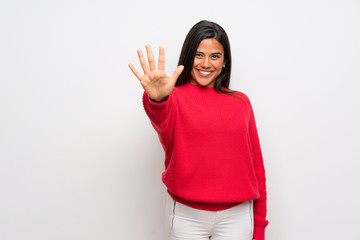 Young Colombian girl with red sweater counting five with fingers