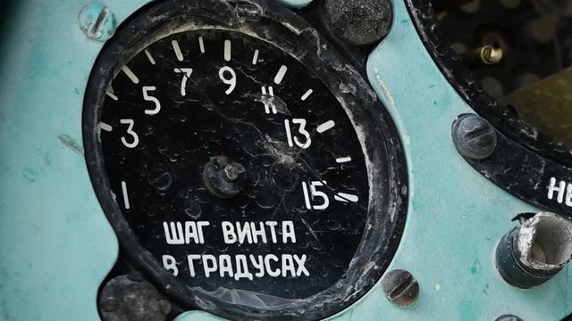 A steady, extreme close up shot of a broken, blue, Russian dashboard with white writings on it. 