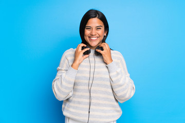 Young Colombian girl with sweater with headphones