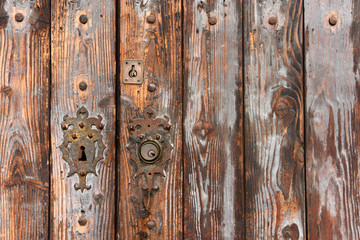 Fragment of an old wooden shabby door with an elegant keyhole. Old town of Palma de Mallorca. Spain.