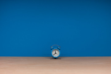lonely blue alarm clock on paper background