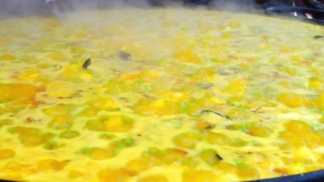 A large pan of paella cooking at a market stall in Portobello Road, London