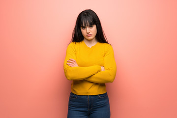 Fototapeta premium Woman with yellow sweater over pink wall feeling upset
