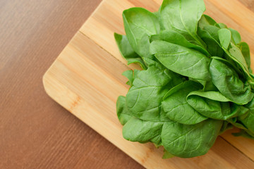 green spinach on a table on a wooden board