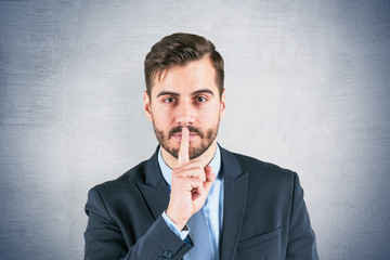 Businessman making hush sign