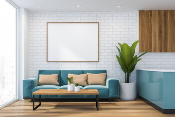 Blue sofa with poster in studio apartment