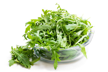 Rocket salad leaves in glass bowl isolated on white