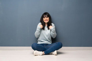 Woman sitting on the floor with surprise facial expression