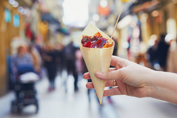 Obraz premium Woman hand holding paper cone with take away jamon