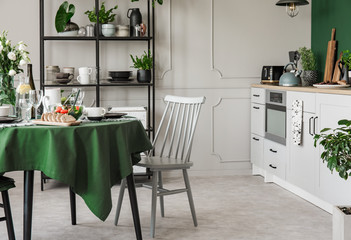 Elegant grey and green kitchen interior with dining room table