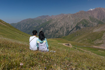 Naklejka premium couple sits in the meadow and looks into the distance