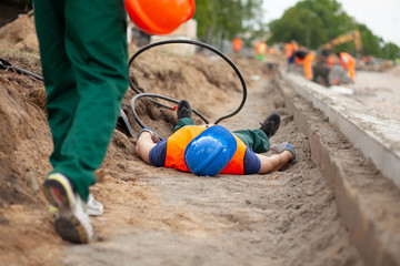 Road construction worker lying on the ground after terrible accident