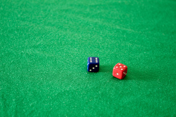 Blue and red dice on green background