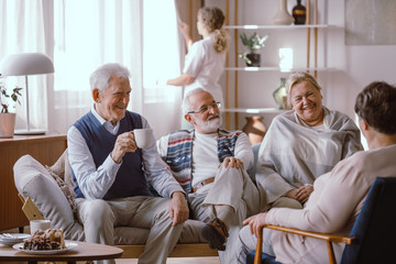 Smiling elderly people talking together in nursing home