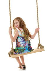 Little girl swinging on a swing