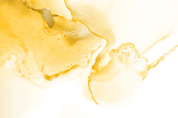 Yellow alcohol ink texture with abstract washes and paint stains on the white paper background.	