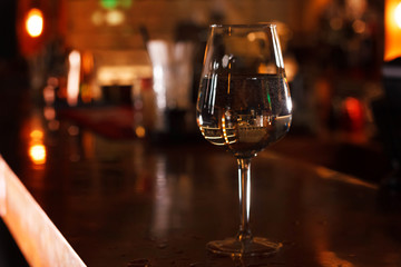 Close-up of a wine glass with water at a bar counter