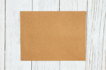 Brown blank greeting card on weathered whitewash textured wood background
