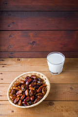 Dried dates and milk on wooden background. Holy month of Ramadan, concept. Righteous Muslim lifestyle. Starvation. Dates in a wooden basket in the style of minimalism. Copy space