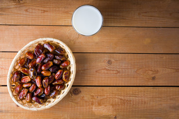 Dried dates and milk on wooden background. Holy month of Ramadan, concept. Righteous Muslim lifestyle. Starvation. Dates in a wooden basket in the style of minimalism. Copy space