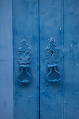 Door knockers on blue door in Lisbon, Portugal.
