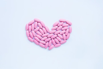 Pink medicine pills on white background.