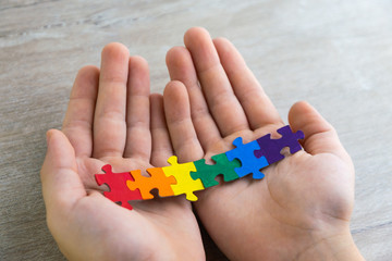 teaching sexual tolerance in school and at home: a boy builds an LGBT flag using puzzles