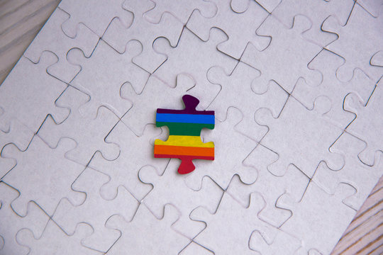 Place of LGBT people in the public structure: puzzle with the coloring of the rainbow flag against a white mosaic, top view - Powered by Adobe
