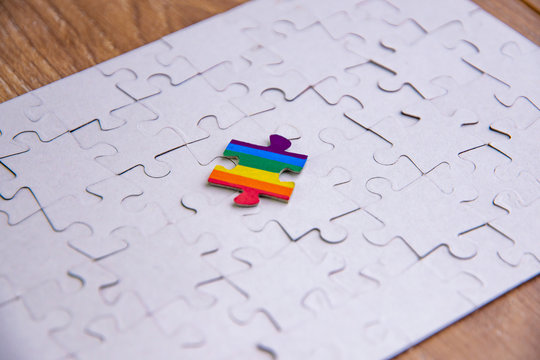 Place of LGBT people in the public structure: puzzle with the coloring of the rainbow flag against a white mosaic, front view