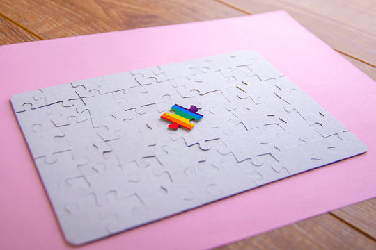 Place of LGBT people in the public structure: puzzle with the coloring of the rainbow flag against a white mosaic, front view - Powered by Adobe