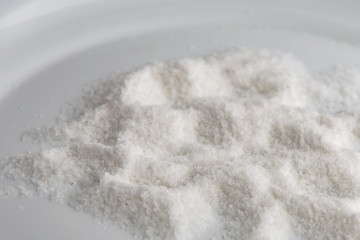 mineral diet: a small pile of sea iodized edible salt on a plate, short focus