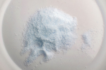 Obraz na płótnie Canvas mineral diet: a small pile of sea iodized edible salt on a plate, short focus, toning
