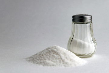 mineral diet: saltcellar with the letter "S" next to a pile of sea salt fluoridated salt on the table