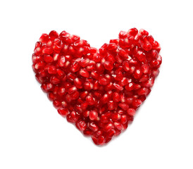 Heart made of pomegranate seeds on white background, top view. Healthy diet