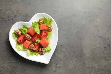 Plate of salad on grey background, top view with space for text. Heart-healthy diet