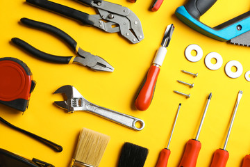 Flat lay composition with construction tools on color background
