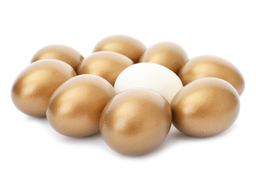 Ordinary egg among golden ones on white background
