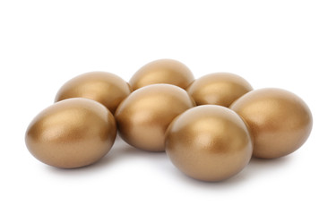 Many shiny golden eggs on white background