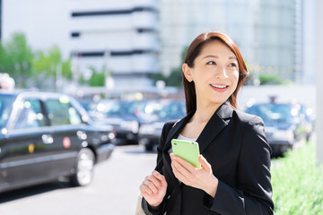 ビジネスウーマン　スマートフォン　駅